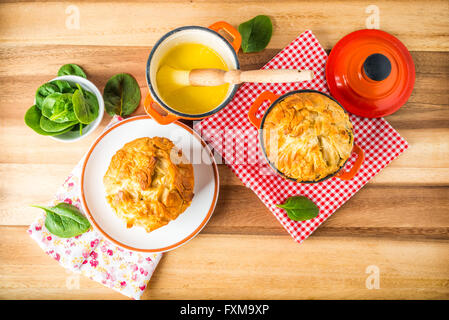 Spanakopita - Greek spinach pie with feta and ricotta, baked in cast iron pots, with melted butter Stock Photo