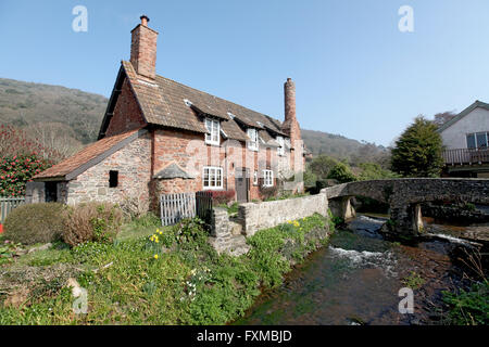 Allerford is a pretty English Village with a ford,packhorse bridge and many stone cottages with round, bread oven chimneys. Stock Photo