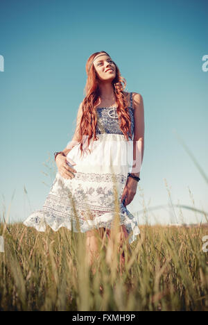 Smiling pretty hippie woman standing in the meadow Stock Photo