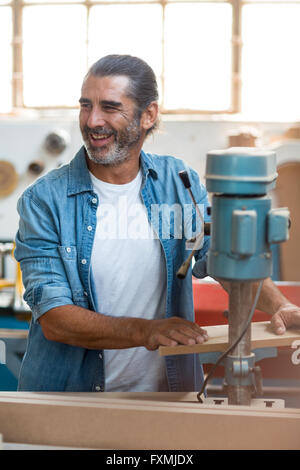 Carpenter using machinery in workshop Stock Photo