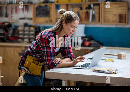 Female carpenter using laptop Stock Photo