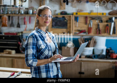 Female carpenter using laptop Stock Photo