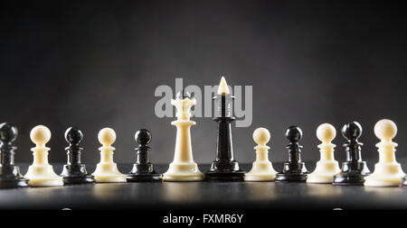 Black and white chess figures on the table over black Stock Photo