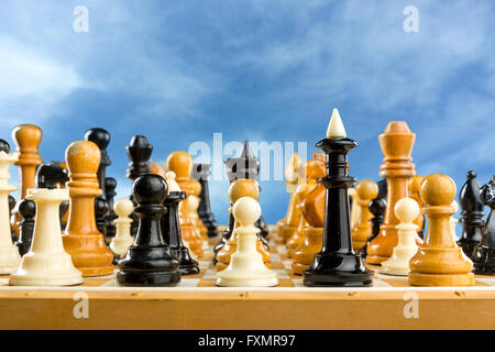 Many chess figures standing on the board over the sky Stock Photo