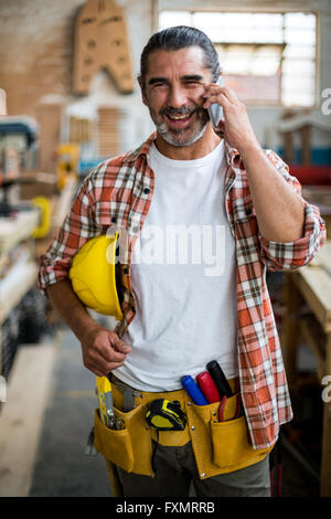 Carpenter talking on mobile phone Stock Photo