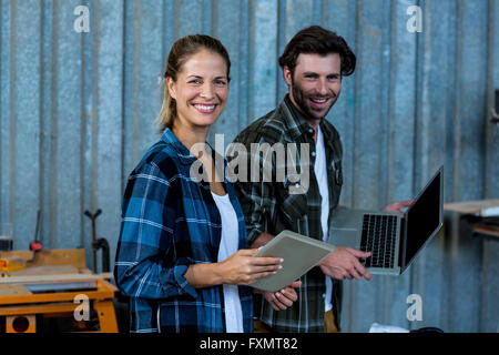 Happy carpenters holding digital tablet and laptop Stock Photo