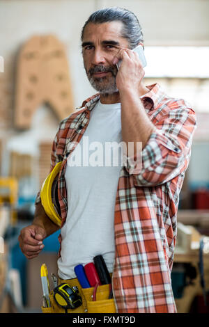 Carpenter talking on mobile phone Stock Photo