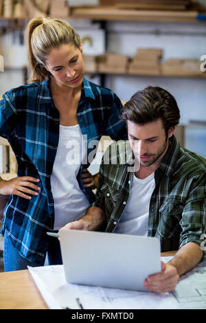 Male and female carpenters using laptop Stock Photo