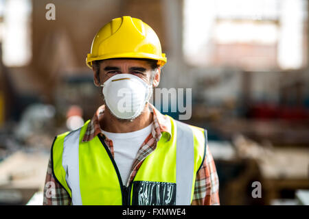 Portrait of carpenter wearing dust mask and hard hat Stock Photo