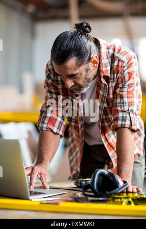 Carpenter using laptop Stock Photo