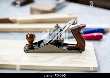 Wooden plank and jack plane on table Stock Photo