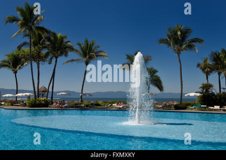 Pool with fountain at Nuevo Vallarta Mexico with Palm trees and vacationers Stock Photo