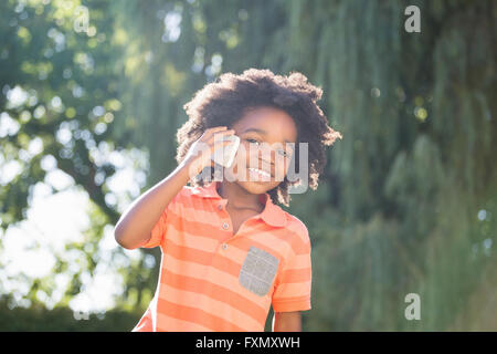 Little boy on the phone in park Stock Photo