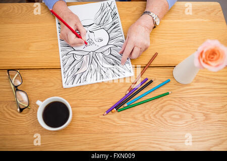 Senior woman colouring in a colouring book Stock Photo