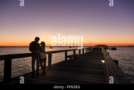Couple on pier at sunset, Melbourne Beach, Atlantic Coast,  Florida Stock Photo