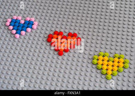 Tambov, Russian Federation - January 24, 2016 Three Lego hearts from Round Bricks 1 x 1 on Lego gray baseplate. Studio shot. Stock Photo