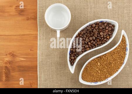 Natural coffee beans versus instant. Soluble and coffee beans on wooden background. Preparing fresh coffee. Stock Photo