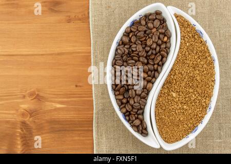 Natural coffee beans versus instant. Soluble and coffee beans on wooden background. Preparing fresh coffee. Stock Photo