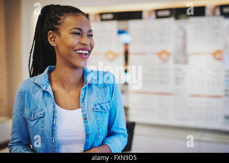 Laughing female entrepreneur standing in her shop Stock Photo