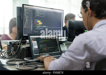 Asian Outsource Developer Looking Screen Sitting At Desk Working Stock Photo