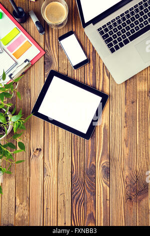 Laptop with other modern electonic devices on desk Stock Photo