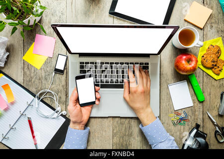 hands of a man using laptop and smartphone Stock Photo
