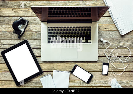 Laptop with other modern electonic devices on desk Stock Photo