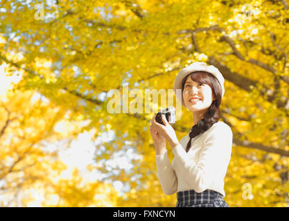 Young Japanese woman with vintage camera in a city park Stock Photo