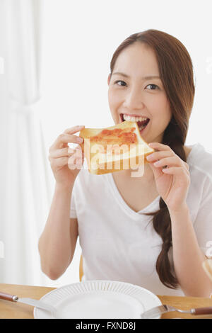Young attractive Japanese woman having breakfast at home Stock Photo