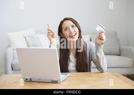 Young attractive Japanese woman doing online shopping at home Stock Photo