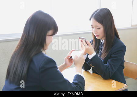 Japanese high-school students with smartphone in classroom Stock Photo