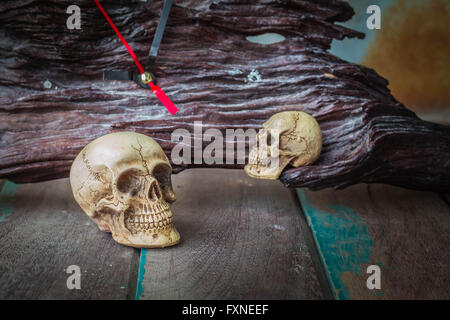 The skull and the clock on the old wooden background. Stock Photo