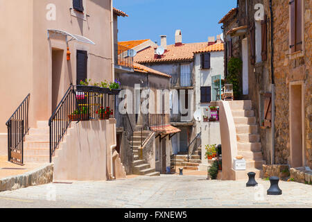 Narrow street of Piana town in bright summer day. Corsica island, France