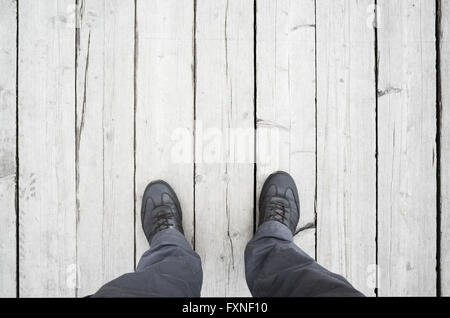 Male feet in leather shoes stand on white wooden floor, first person view Stock Photo