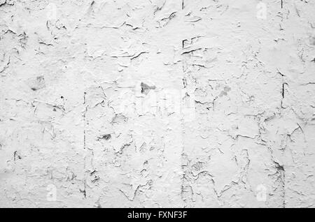 Cracked flaking white paint on old stone wall, background photo texture Stock Photo