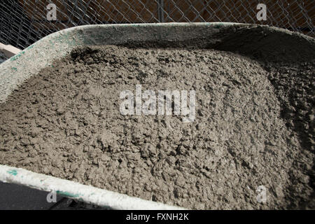 Wet concrete mixed in wheelbarrow - USA Stock Photo