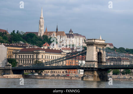 Skyline of the River Danube, the spire of  Matthias Church and the Széchenyi Chain Bridge in Budapest in Hungary. The Chain Bridge was designed by Stock Photo
