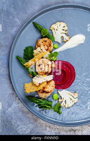 Scallops with beetroot and cauliflower puree, asparagus and parmesan crisp Stock Photo