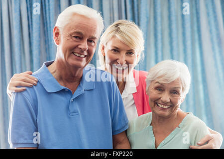 Nurse hugging a senior couple Stock Photo