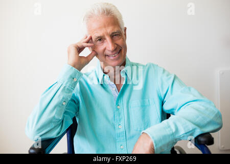 Smiling senior man sitting in a wheelchair Stock Photo