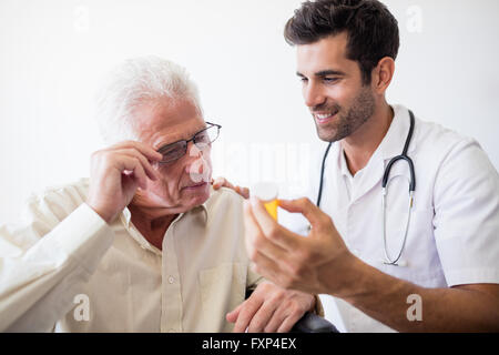 Nurse giving pills to senior man Stock Photo