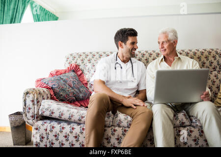 Nurse and senior man using laptop Stock Photo
