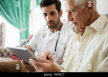 Nurse and senior man using tablet Stock Photo