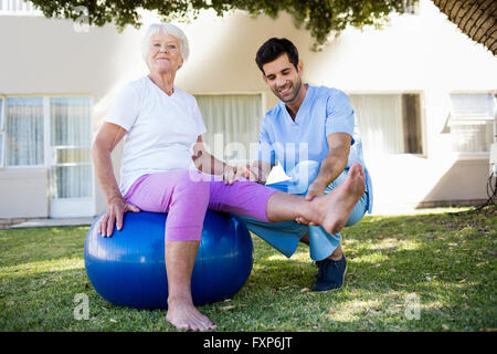 Nurse helping senior woman doing exercises Stock Photo