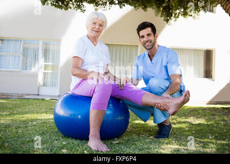 Nurse helping senior woman doing exercises Stock Photo