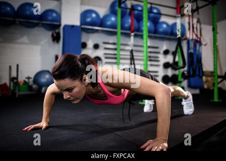 Determined woman doing push ups Stock Photo