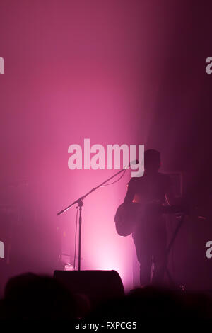 Musician illuminated in silhouette on stage Stock Photo