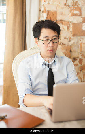 Casual businessman working while looking boring in outdoor office Stock Photo