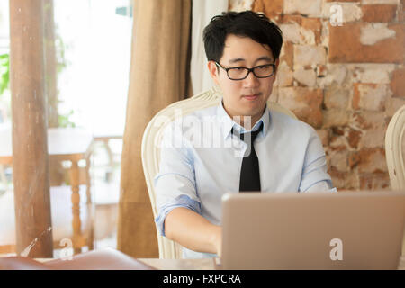 Casual businessman working while looking boring in outdoor office Stock Photo
