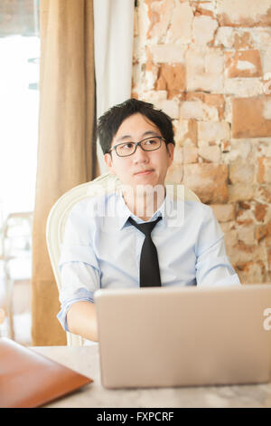 Young Asian casual businessman thinking while working in outdoor scene Stock Photo